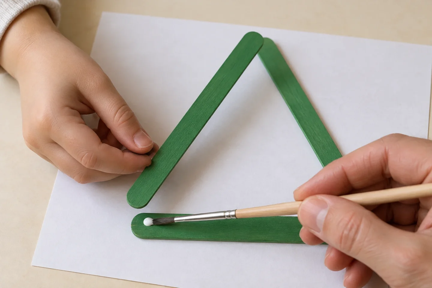 Add a small glue dot where the straight craft sticks overlap, then lower the lifted stick into place.