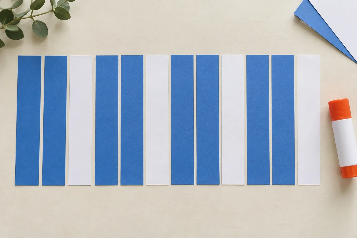 Twelve paper strips arranged in four blue-blue-white repeating units