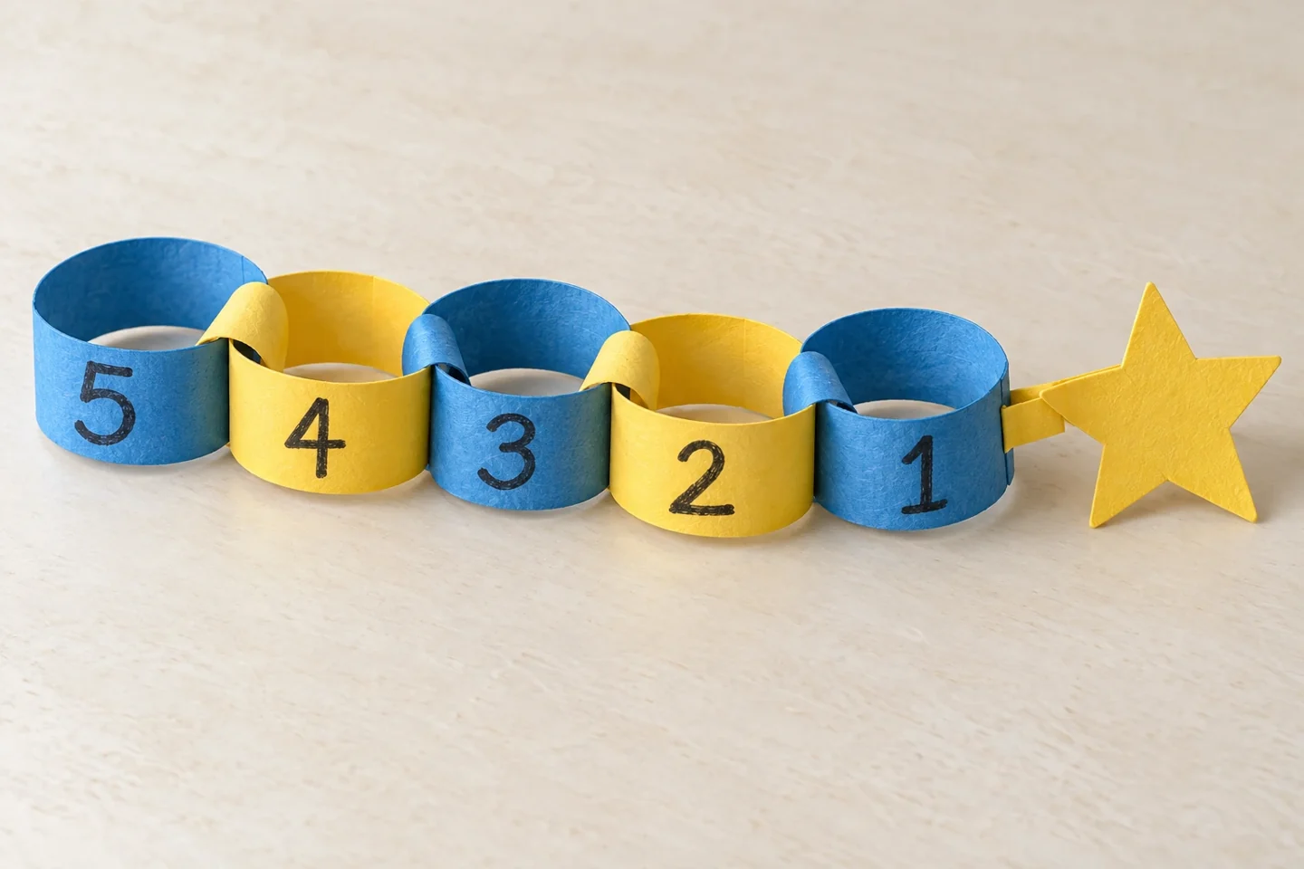 Close entire complete five-link chain in order 5 4 3 2 1, clearly separate paper loops each joined with 2 cm overlap, number-one end attached to star by short paper tab
