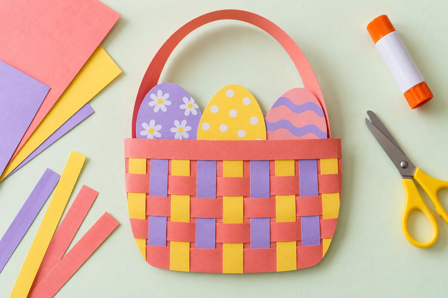 A finished checkerboard paper basket with three decorated eggs