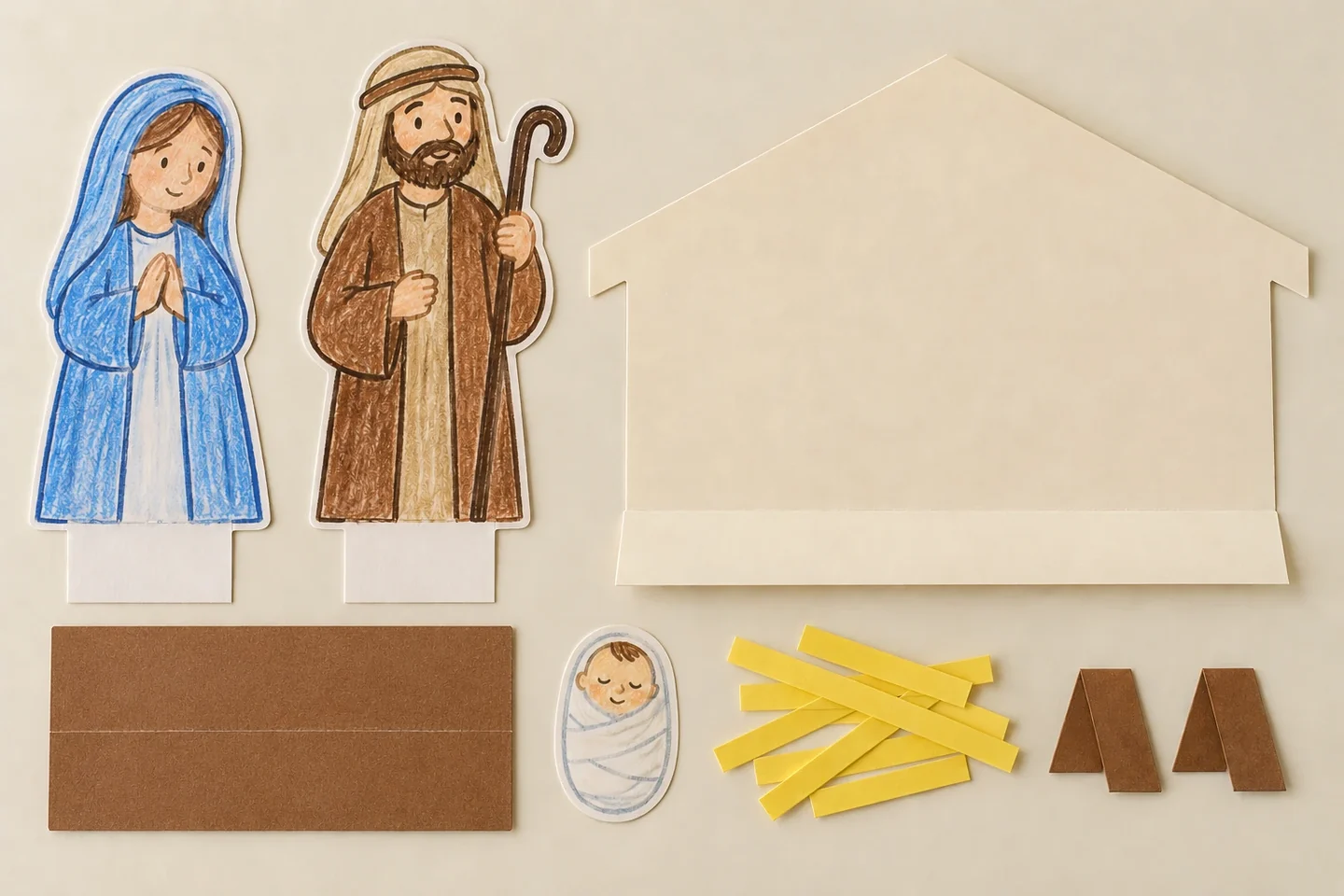 Two drawn paper figures with half-inch bottom tabs still unfolded, a scored manger rectangle and a roof-shaped backdrop with a one-inch bottom support