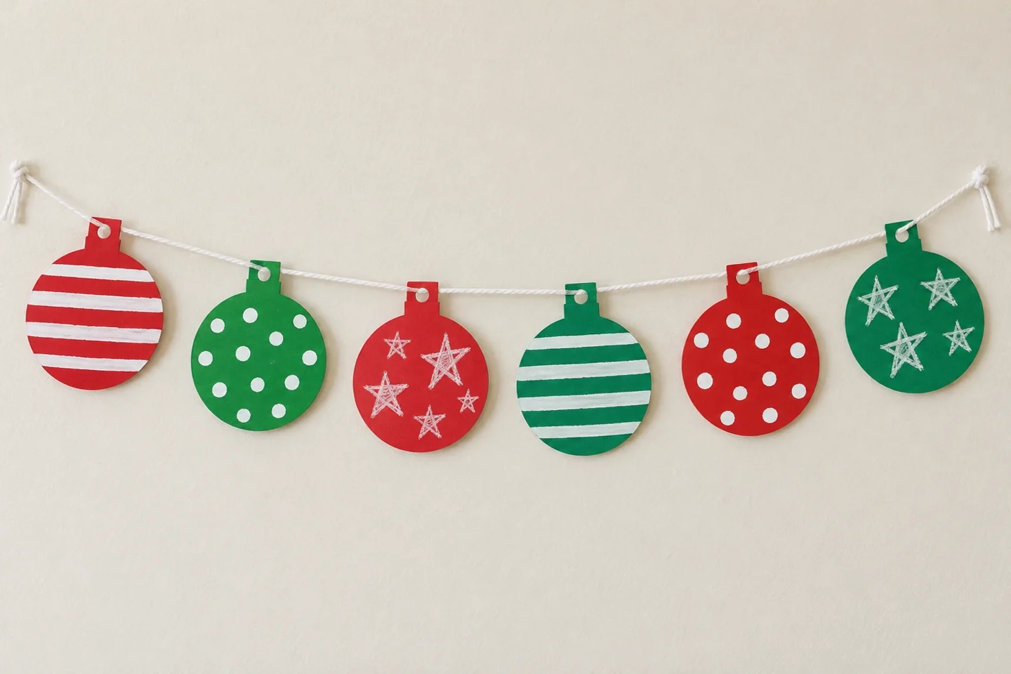 One six-circle paper ornament garland with different stripes dots and child drawings, one-to-two-inch edge gaps and short end ties