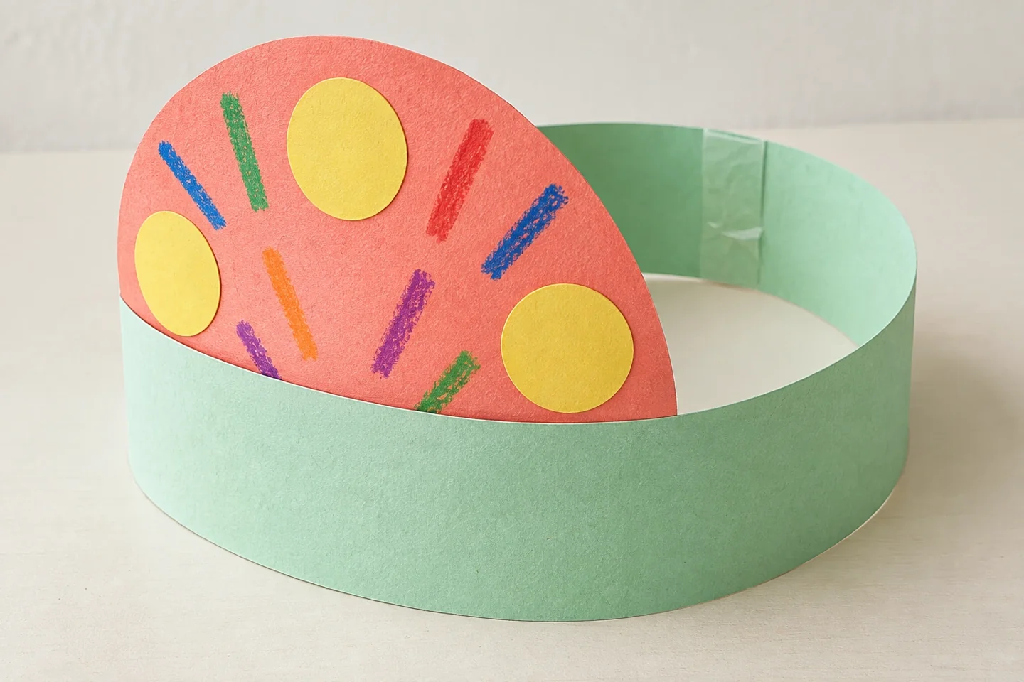 Completed broad headband ring with seam taped after fitting, semicircle upright above front center, lightweight circles and stripes