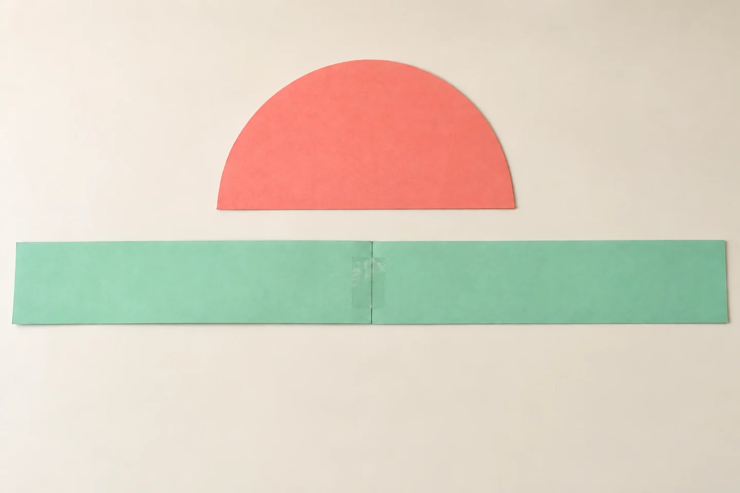 A flat mint paper band with a taped overlap beside a separate coral semicircle