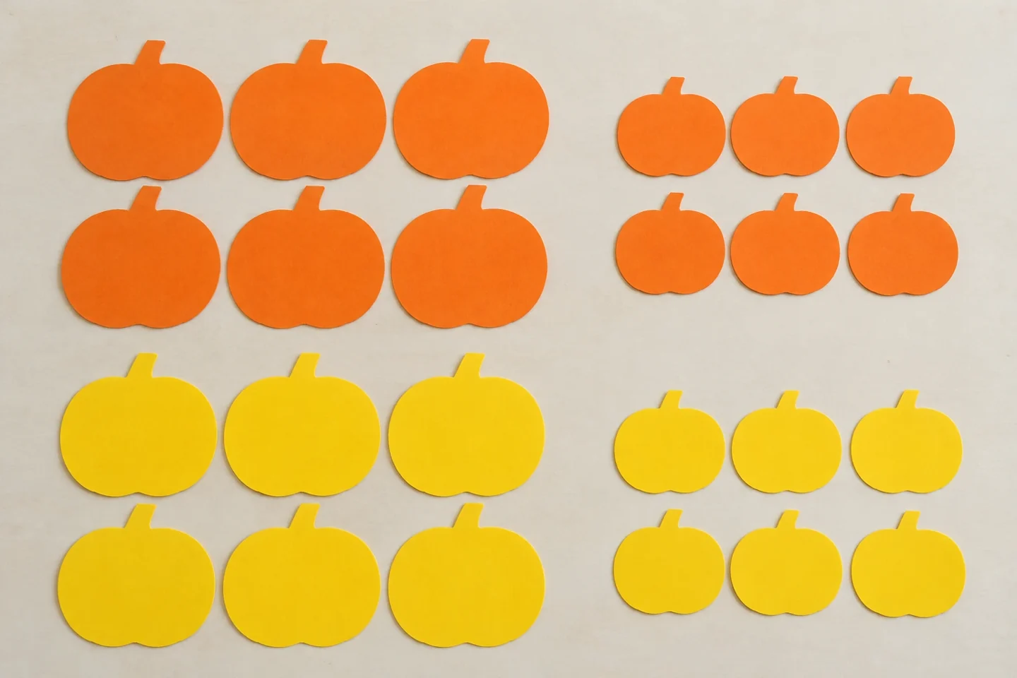 Twenty-four pumpkins sorted into four groups of six by color and size.