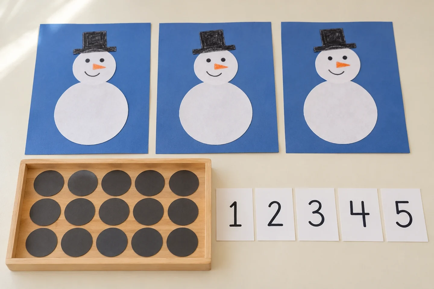 Three blue mats with two plain white snowman circles glued to each